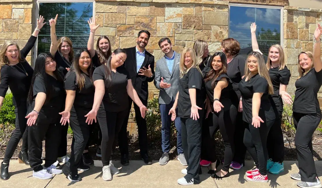 Anthony Patel Orthodontics team with doctors and clinicians in black scrubs having fun